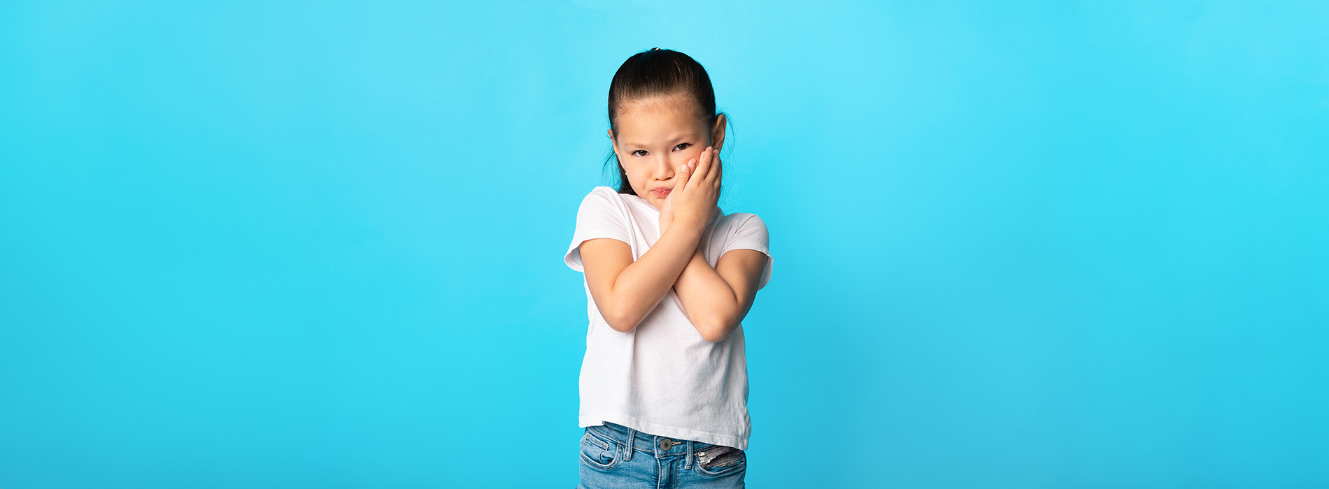 The image features a young child standing in front of a blue background with their arms crossed, appearing to be making a peace sign with their fingers.