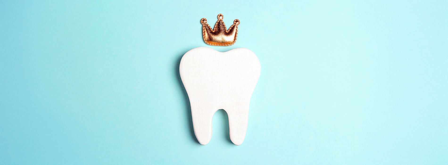 The image shows a tooth with a crown on top placed against a blue background, with a small white border framing the scene.