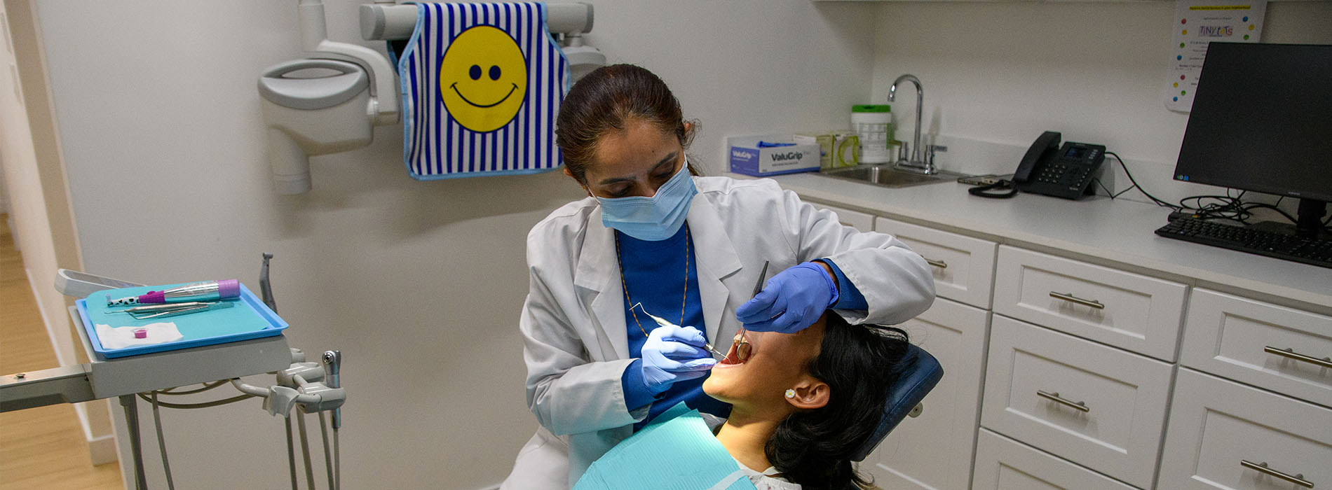 A dental hygienist performing a dental cleaning procedure on a patient.