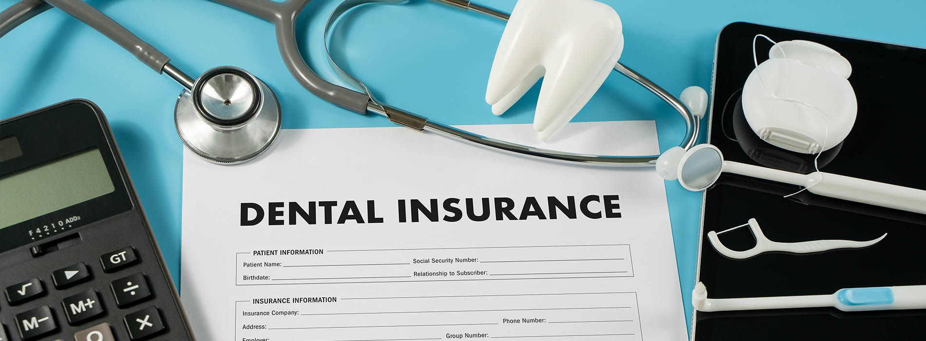 The image shows a document titled  DENTAL INSURANCE  with various medical equipment, including a stethoscope, a blood pressure cuff, and a dental mirror, placed on top of it alongside a calculator and a smartphone.